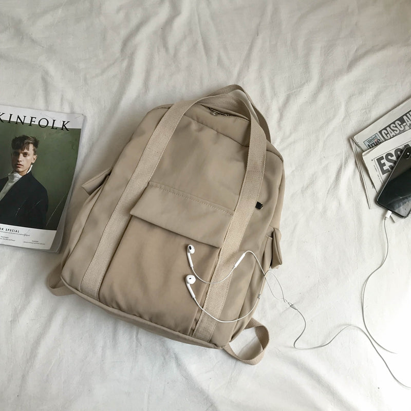 Sac à dos beige avec compartiments pratiques